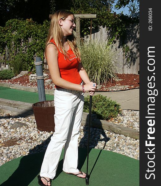 Girl with putting green on miniature golf course. Girl with putting green on miniature golf course