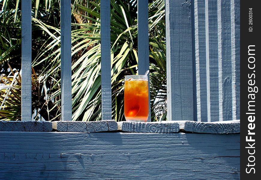 A delicious glass of iced tea on the deck of a tropical paradise. A delicious glass of iced tea on the deck of a tropical paradise.