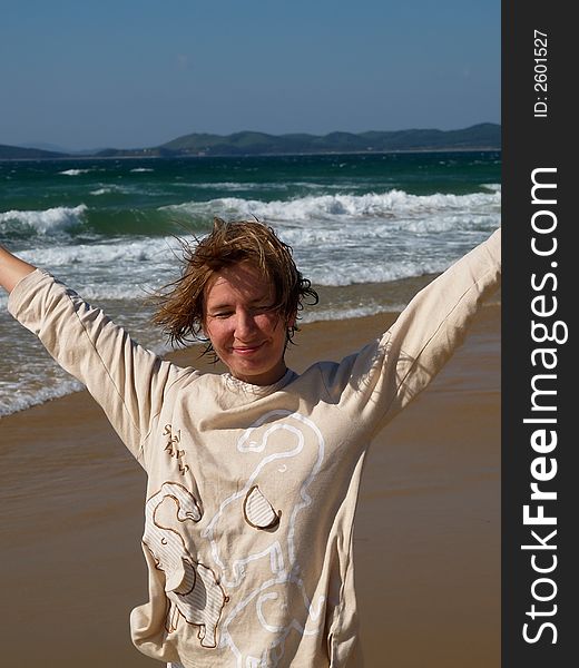 Happy resting girl on the sand beach against storm sea. Happy resting girl on the sand beach against storm sea