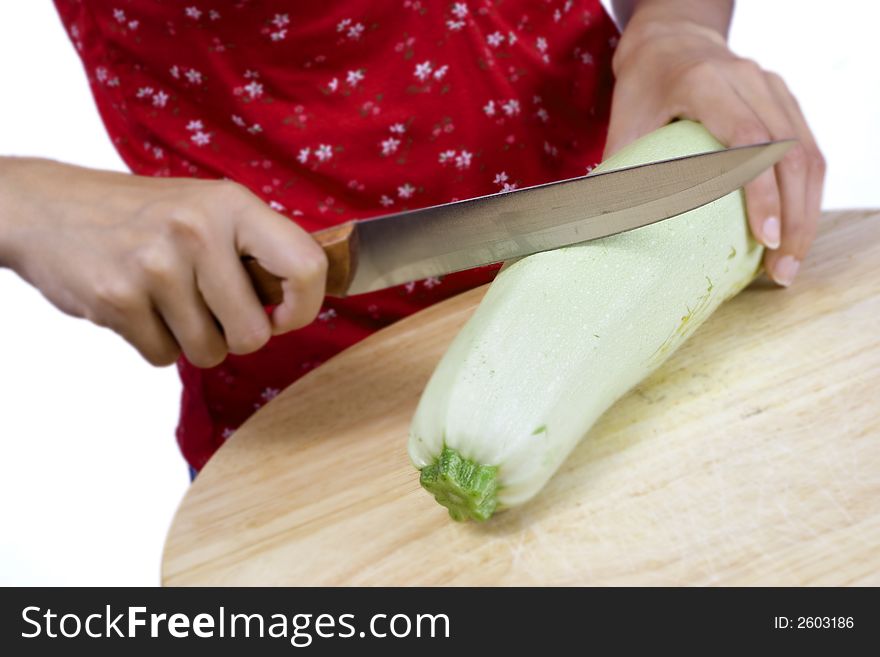 Girl cutting vegetable marrow on wood