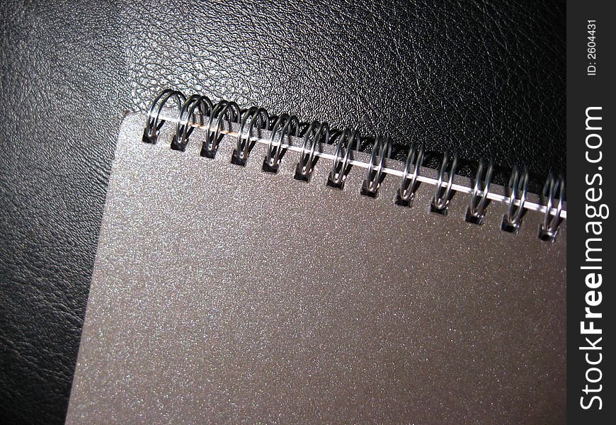 Brown Spiral Notebook on Black Leather Background. Brown Spiral Notebook on Black Leather Background