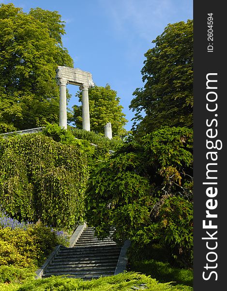 The remains of a Roman building standing isolated and mysterious, in the woods, with steps leading up towards them. Space for text in the sky. The remains of a Roman building standing isolated and mysterious, in the woods, with steps leading up towards them. Space for text in the sky.