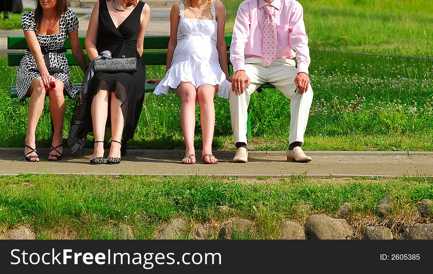 Legs of group of people sitting on a bench. Legs of group of people sitting on a bench