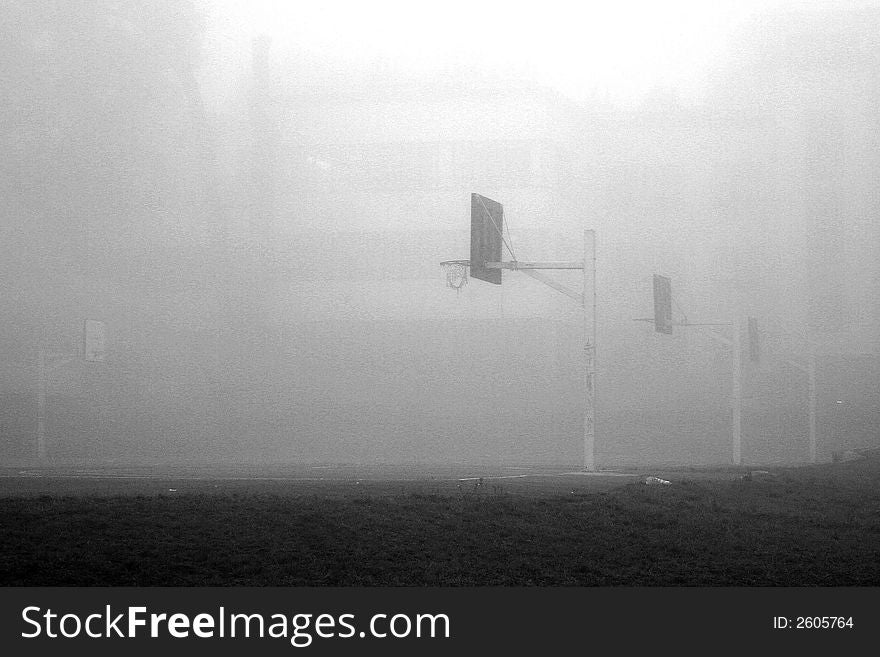 Multiple rusty basketball boards in fog near an old. Multiple rusty basketball boards in fog near an old