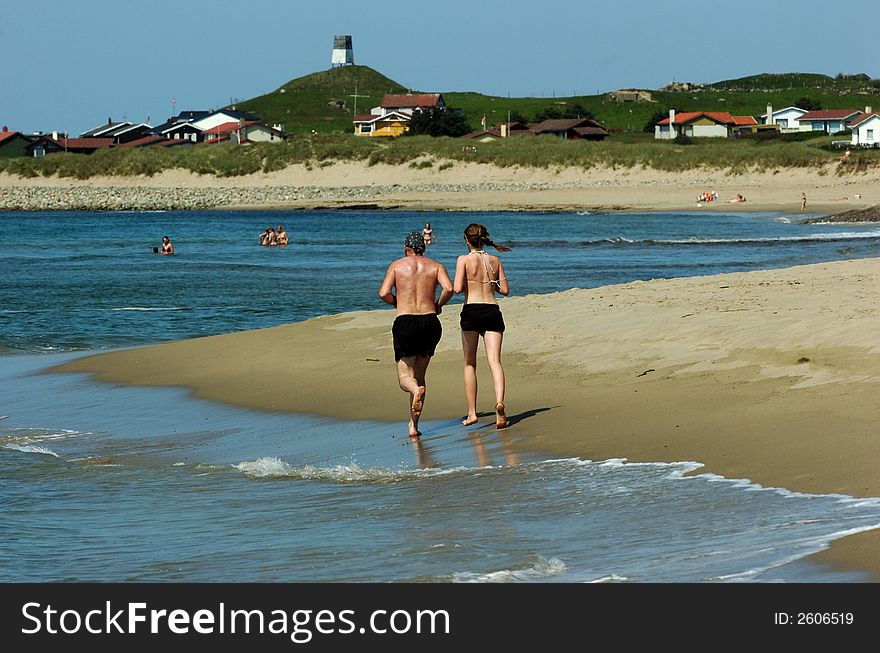 Young Couple Running On Beach