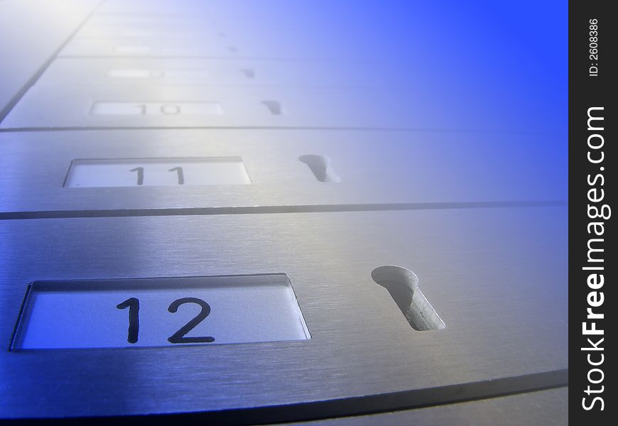 Close-up of mail boxes with key holes. Overlaid with blue lighting effect.