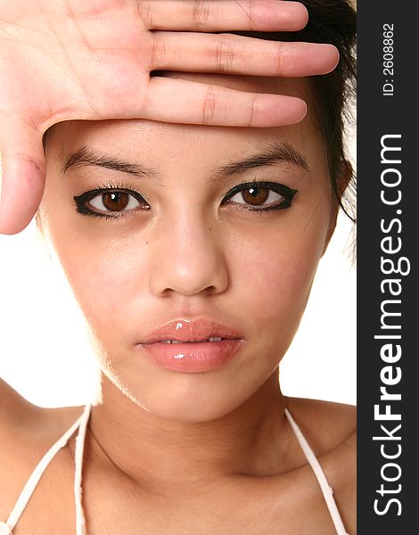 Close up face of beautiful brunette with her hand on her forehead. shot with rim light isolated on white. very sharp eye. Close up face of beautiful brunette with her hand on her forehead. shot with rim light isolated on white. very sharp eye