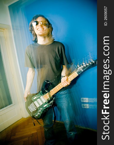 Young man playing electric guitar, zoom and strobe lighting. Young man playing electric guitar, zoom and strobe lighting.