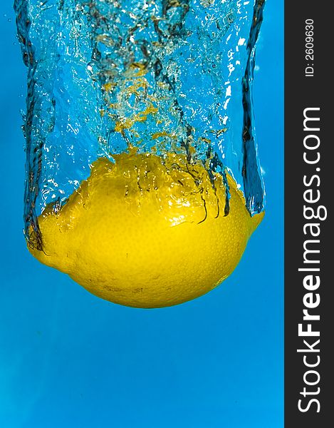 A lemon plunging into refreshing cool water. A lemon plunging into refreshing cool water