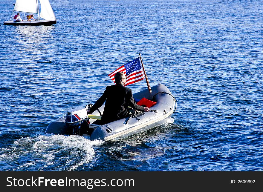 Guy in a three piece suit motoring his yacht tender. Guy in a three piece suit motoring his yacht tender