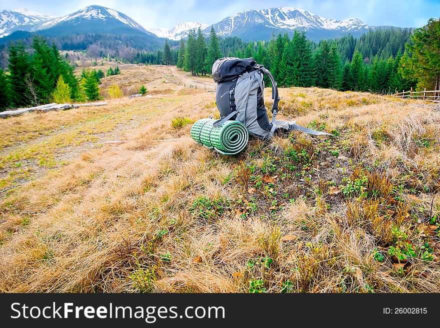 Tourists backpack in mountains landscape under blue sky