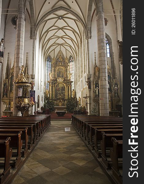 Cesky krumlov, inside of a church with rows of benches. Cesky krumlov, inside of a church with rows of benches