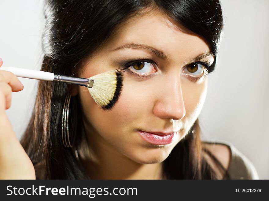 Portrait of beautiful young adult woman applying cosmetic. Portrait of beautiful young adult woman applying cosmetic