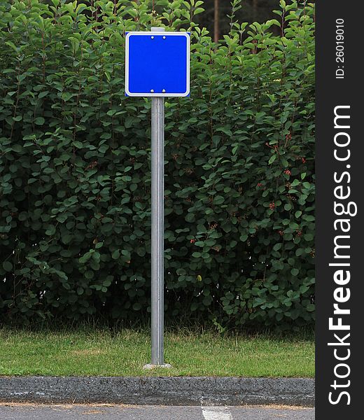 Blank blue sign on pole with green background. Blank blue sign on pole with green background.