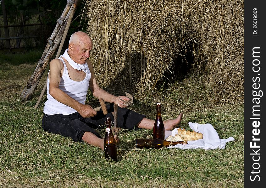 Senior farmer using scythe to mow the lawn traditionally. Are important: the sickle, hammer and anvil. This operation was carried out at the end of the day. the food was bread, cheese and wine. A scythe is an agricultural hand tool for mowing grass, or reaping crops. It was largely replaced by horse-drawn and then tractor machinery, but is still used in some areas of Europe and Asia. Senior farmer using scythe to mow the lawn traditionally. Are important: the sickle, hammer and anvil. This operation was carried out at the end of the day. the food was bread, cheese and wine. A scythe is an agricultural hand tool for mowing grass, or reaping crops. It was largely replaced by horse-drawn and then tractor machinery, but is still used in some areas of Europe and Asia.