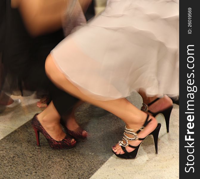 Women in high heeled shoes dancing at a party. Women in high heeled shoes dancing at a party