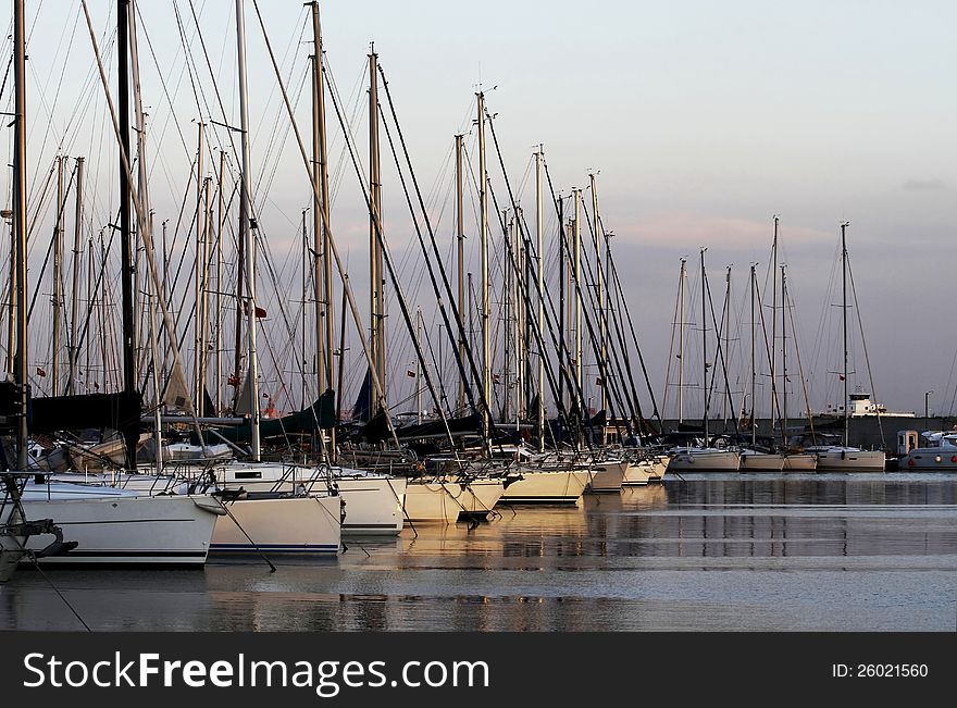 View of the marina and sunset sailing yachts. View of the marina and sunset sailing yachts