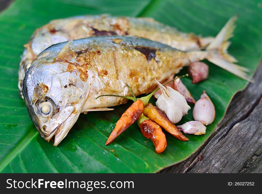 Fish grilled on a banana leaf background