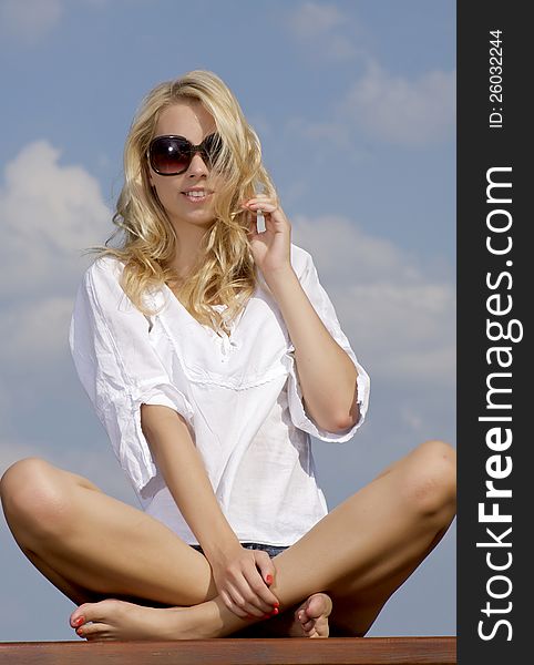 Beautiful girl in sunglasses on  blue sky