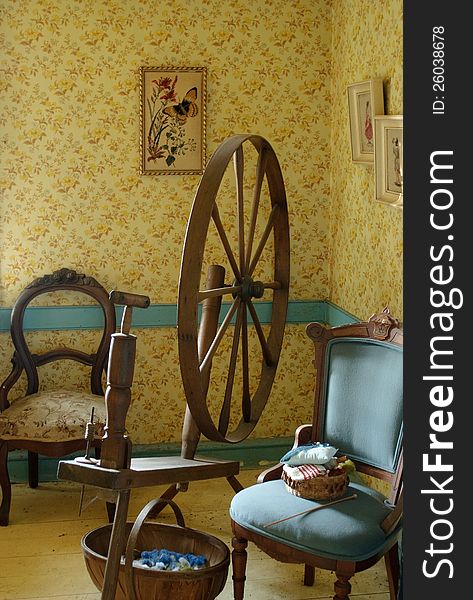 Parlour room circa 1800s with antique spinning wheel and knitting. Parlour room circa 1800s with antique spinning wheel and knitting