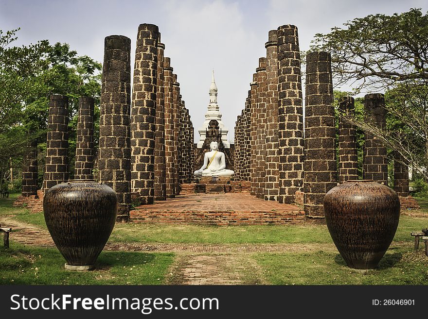 A White sitting Buddha statue red pillar brick  in Thailand