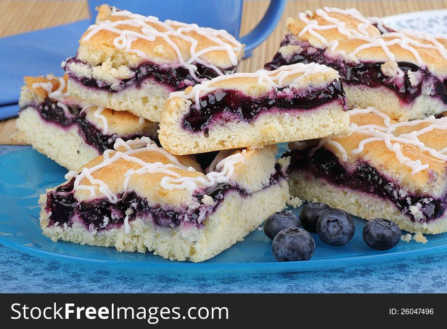 Stacked blueberry bars and berries on a platter