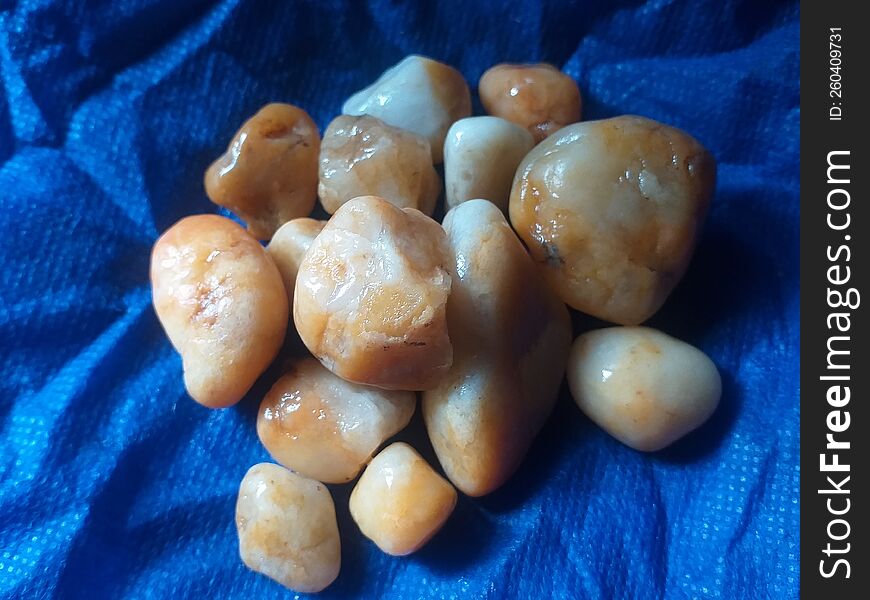 Yellow calcite gemstones uncut in the blue bag background