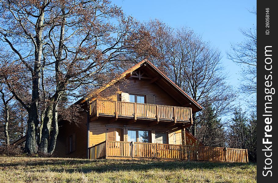 Wooden chalet or a weekend house on the edge of a forest at the autumn or fall season. Wooden chalet or a weekend house on the edge of a forest at the autumn or fall season.