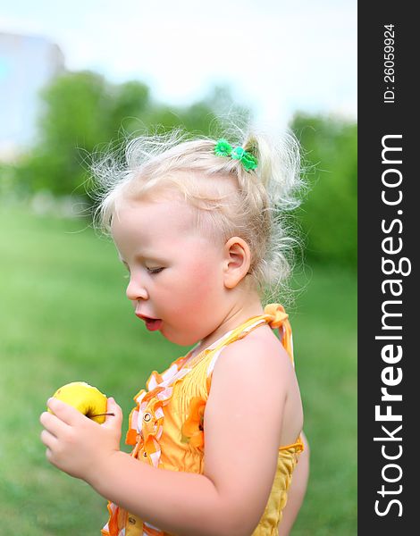 Portrait of a girl with an apple in the park