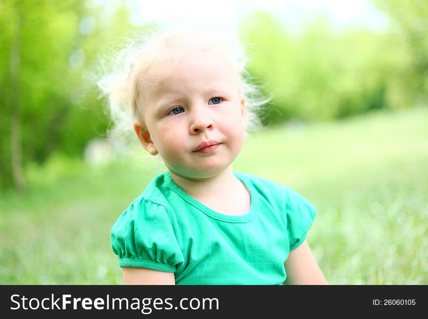 Portrait of a girl child blond in park