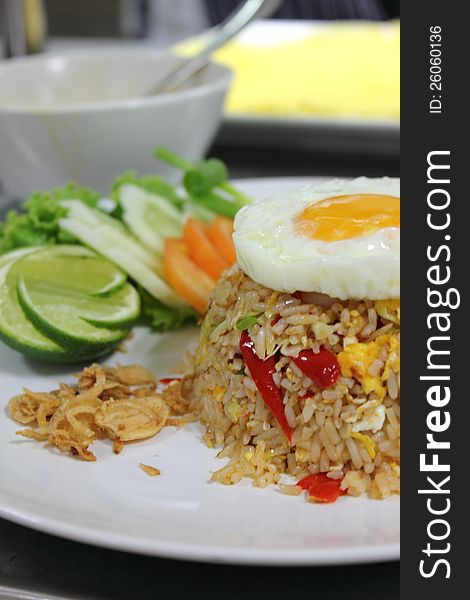 Fried rice with fried egg. Tomato and lemon