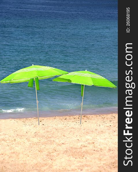 Two Green Sun Umbrellas On The Beach