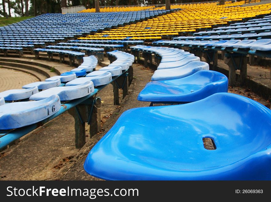 In the open air amphitheater with blue and yellow chairs. In the open air amphitheater with blue and yellow chairs