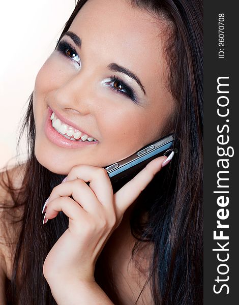 A close up portrait of a brunette beautiful girl talking on the phone. A close up portrait of a brunette beautiful girl talking on the phone
