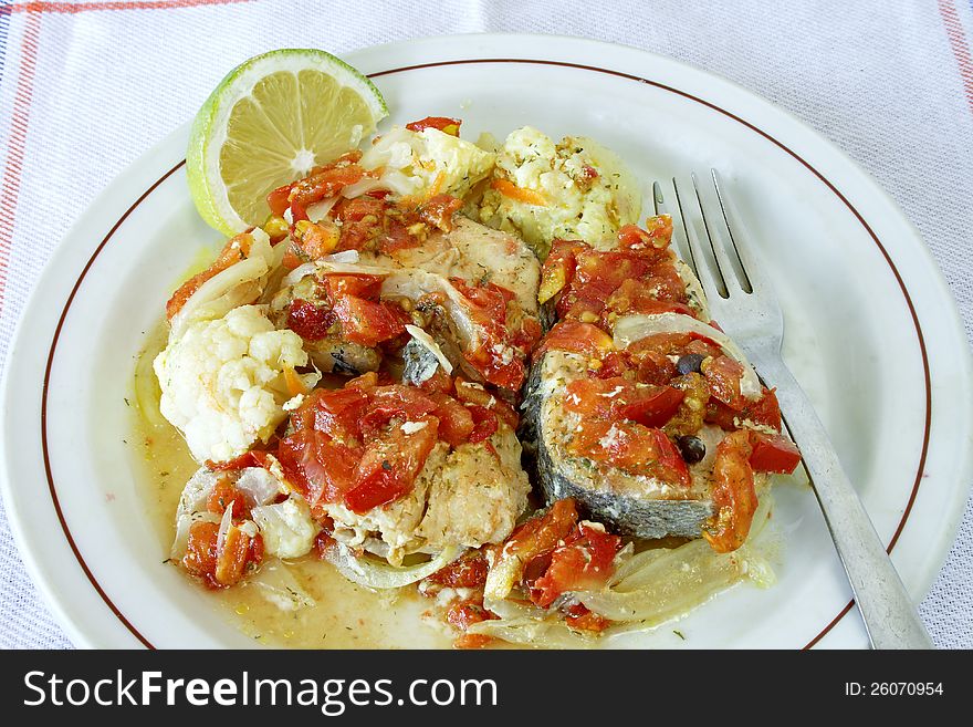 Baked fish with vegetables on plate. Baked fish with vegetables on plate