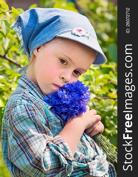 The sad child with a bouquet of wild flowers. The sad child with a bouquet of wild flowers