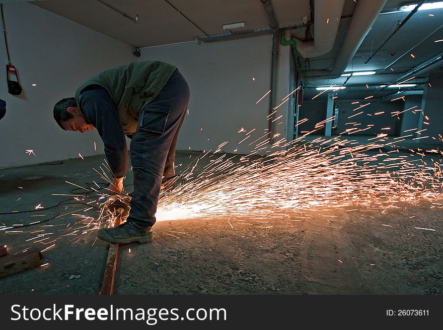 Man with a metal grinder grinding, sparks