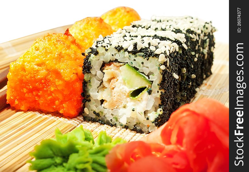 Rolls with black roe and sesame and baking sushi on bamboo mat