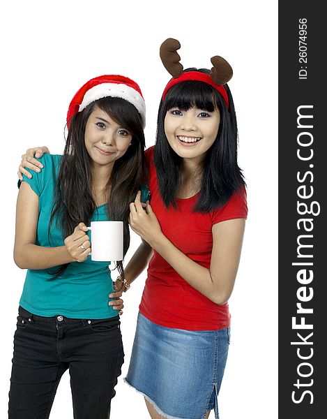 Two girls celebrate christmas with drinking coffee isolated over white background. Two girls celebrate christmas with drinking coffee isolated over white background