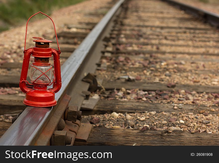 A vintage railroad lamp on a set of railroad tracks. A vintage railroad lamp on a set of railroad tracks.