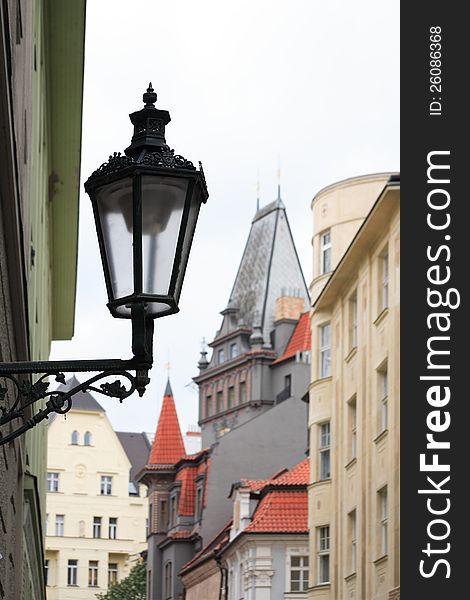 Vintage street lamp on city background with red tiling roofs