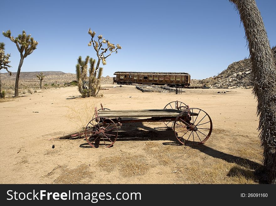 Burned out railroad car and old wagon in the California desert. Burned out railroad car and old wagon in the California desert