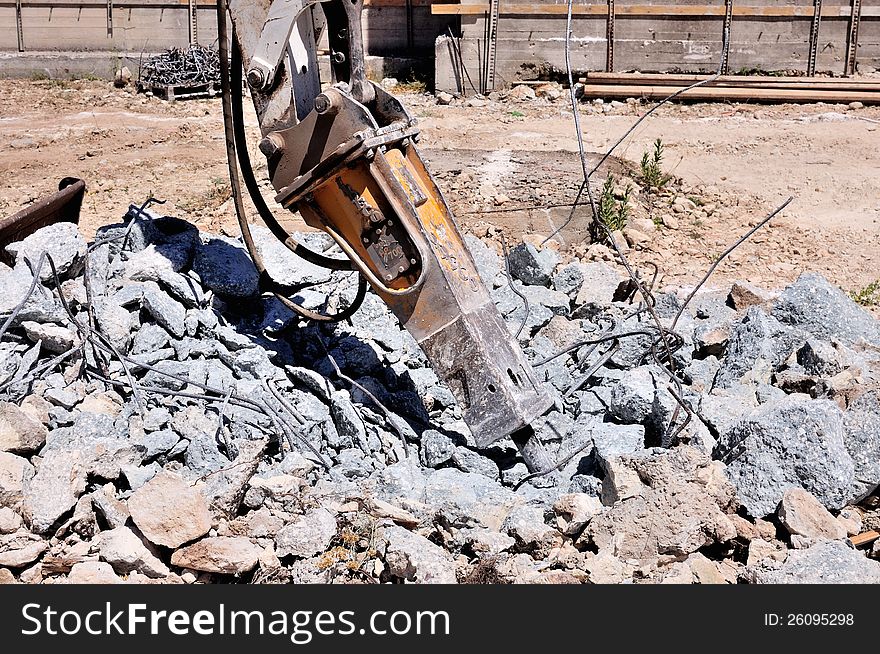 Excavator with hammer demolishes concrete structure for the foundation of new building