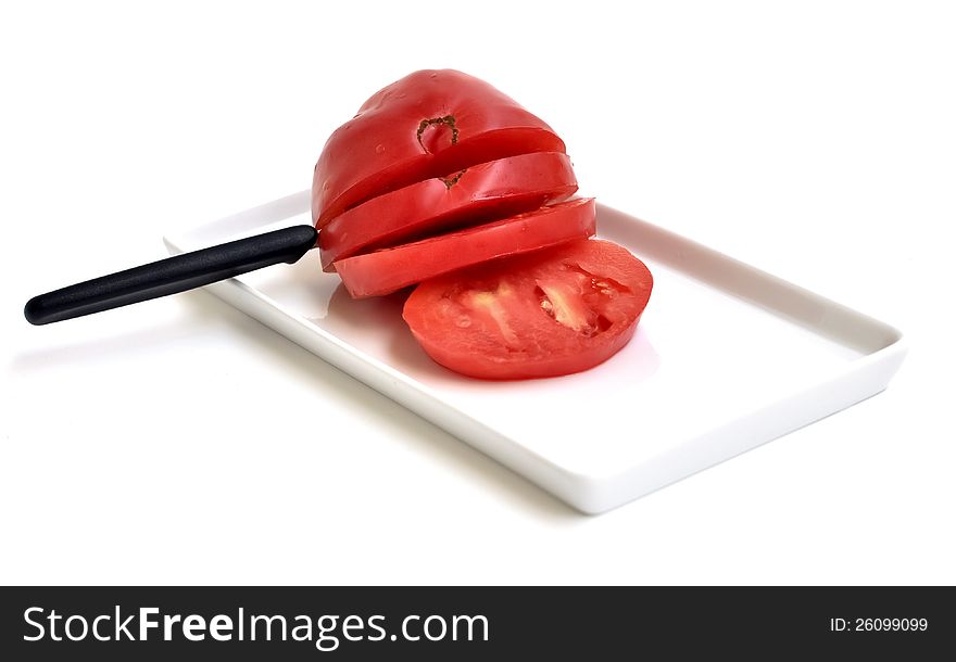 A sliced tomato on a rectangular plate