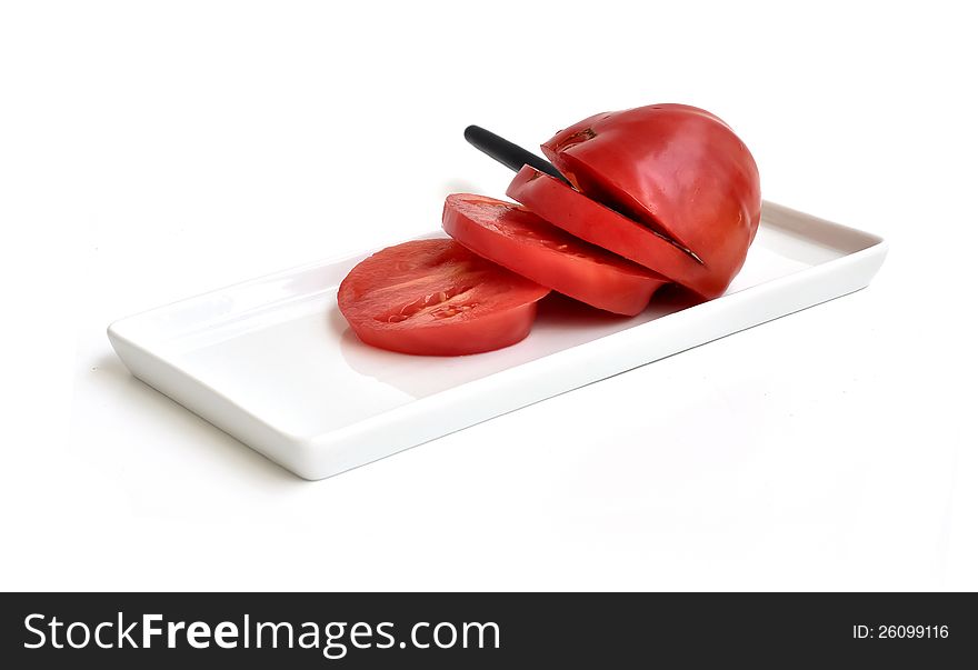 A sliced tomato on a rectangular plate. A sliced tomato on a rectangular plate