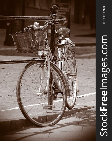 An old bicycle against some railings.