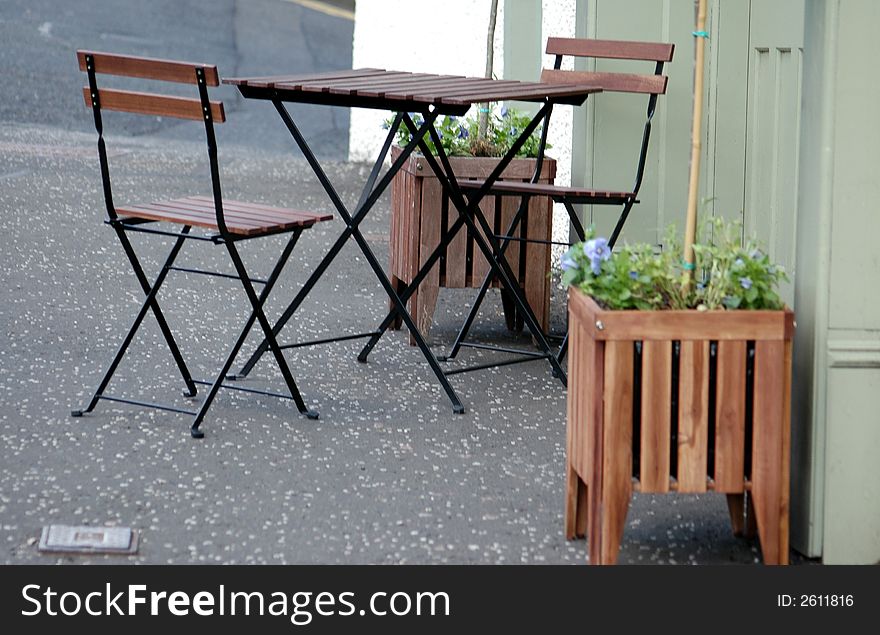 Empty table and chairs outside a coffee shop.