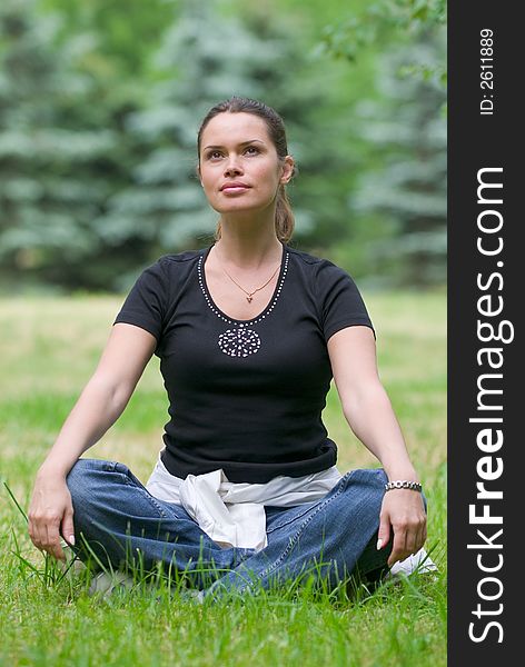 Woman doing yoga exercise on a fresh grass in a park. Woman doing yoga exercise on a fresh grass in a park