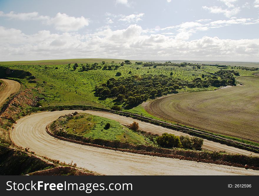 Hilly green landscape with winding country roads and fields. Hilly green landscape with winding country roads and fields.