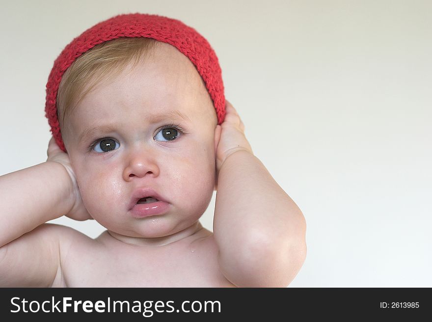 Image of cute toddler holding his hands over his ears